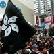 A protester holds up a black version of Hong Kong's flower-emblazoned flag during a packed pro-democracy rally.