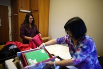 A student and her mom are unpacking in a dorm room. 