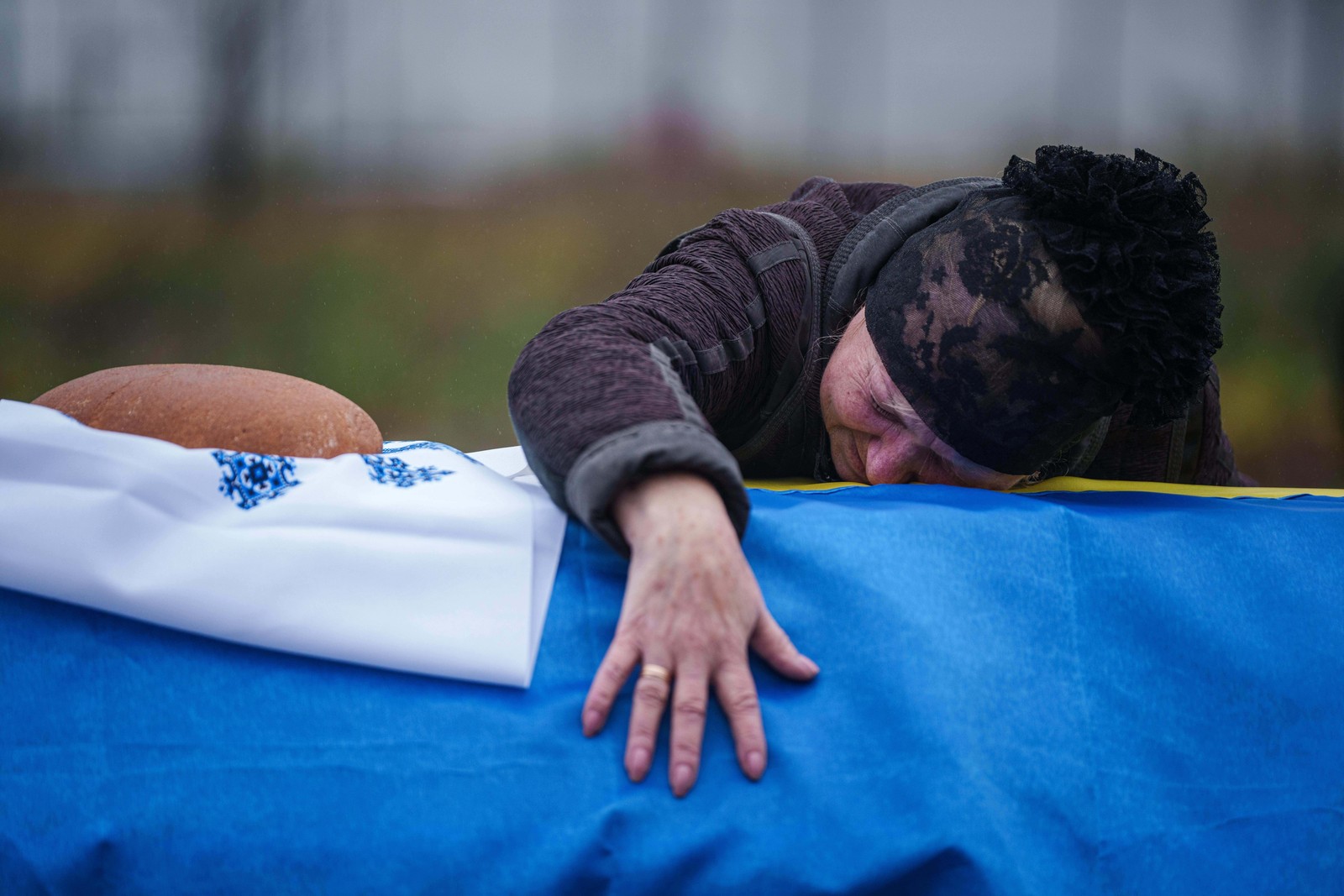 A mother cries at the flag-draped coffin of her son, a Ukrainian serviceman who was killed in fighting with Russian forces.