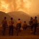 a row of people look out on the Line Fire in the hills