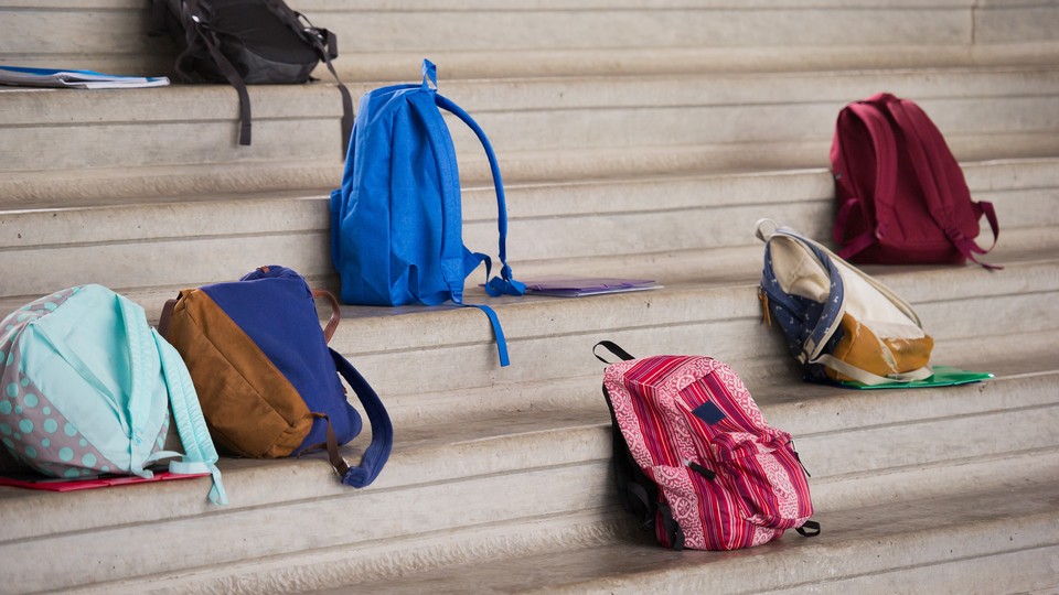 Different colored backpacks scattered on the bleachers