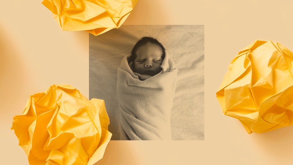 A black-and-white photo of a sleeping infant wrapped in a light colored blanket is surrounded by three pieces of yellow crumpled-up paper