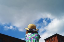 A girl looking at the sky, seen from behind