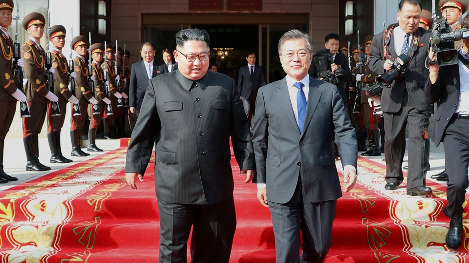 Kim Jong Un and Moon Jae In walking down carpeted steps