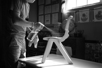 A person in a mask and gloves disinfects a child's chair.