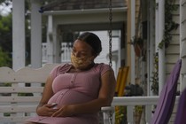 a pregnant person wears a face mask