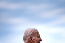 A photograph of Joe Biden's head in profile against a hazy blue sky