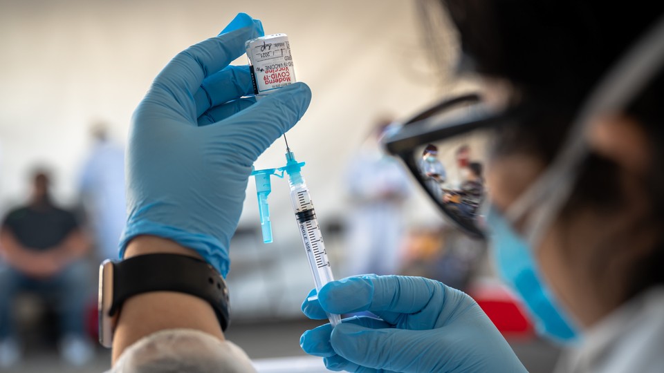 A health-care worker prepares a Moderna COVID-19 vaccine in San Francisco, March 1, 2021