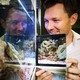 Alex Jordan holds a mirror up to a cleaner-wrasse tank.