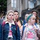 The five main characters in "Derry Girls" walking somberly down a neighborhood street
