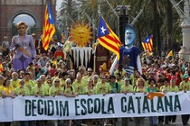 Demonstrators carry a banner, which reads: "Decided, Catalan school."