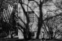 Black-and-white photo of American flag hanging from college building