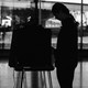 A photo of a voter in silhouette using a voting booth at a polling station