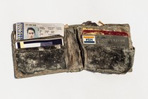 Dusty wallet containing ID, credit card, and other items