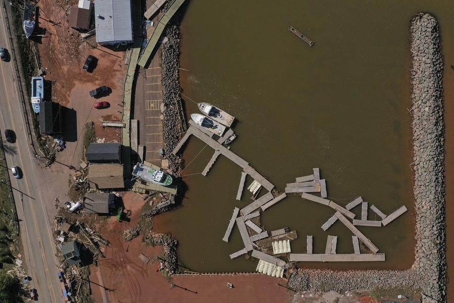 An aerial view of a storm-damaged marina, with floating docks pushed out of position