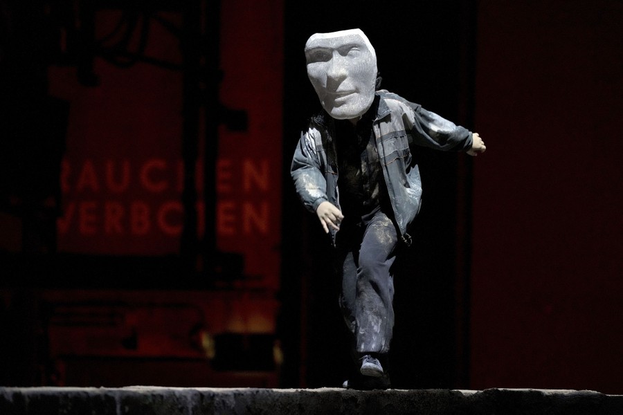 A performer wears a large mask while on stage.