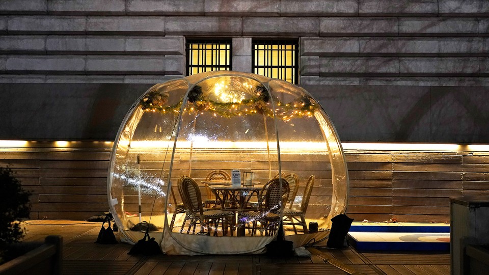 A table with chairs set inside a plastic igloo