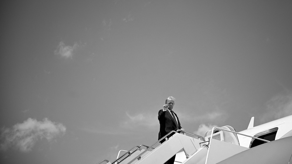 Donald Trump holds up a fist before boarding a plane