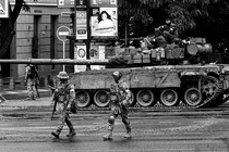 A black-and-white image shoes Wagner mercenaries walking next to a tank on a street in Rostov-on-Don.