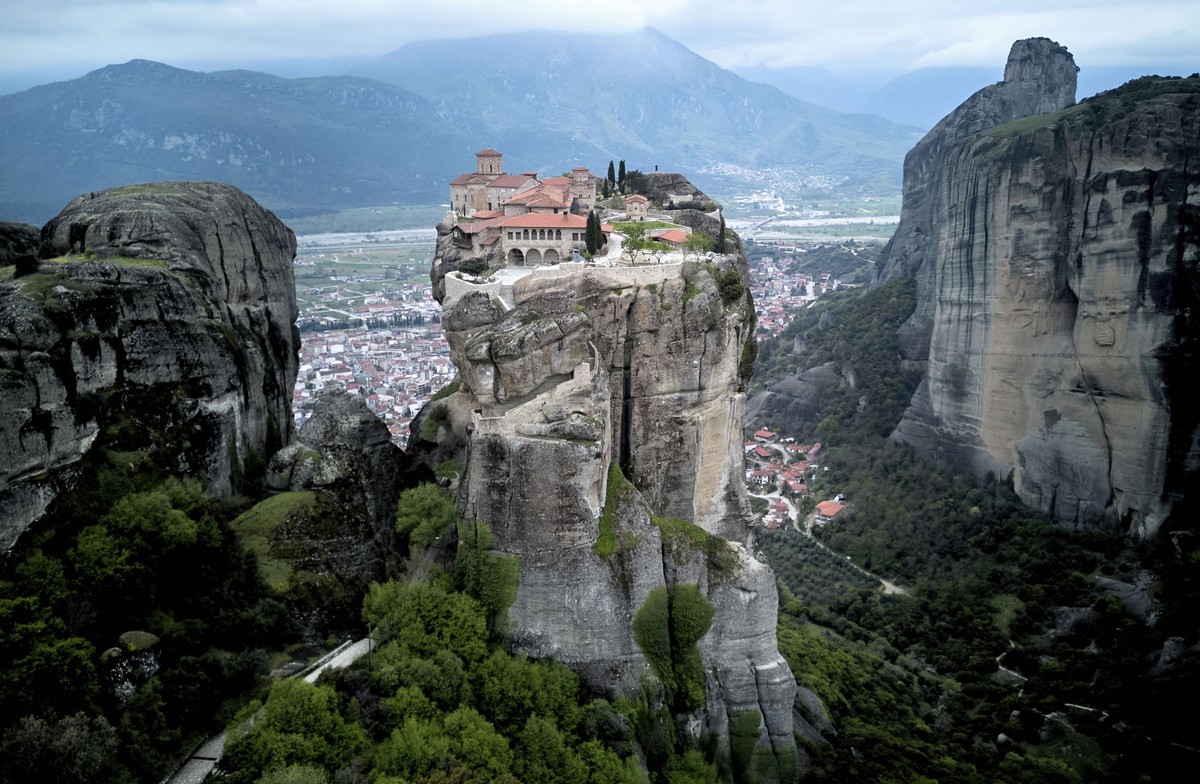 A Greek monastery, perched atop a narrow rock spire with steep cliffs all around