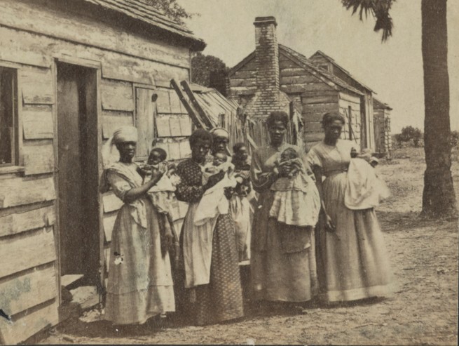 Photograph of several women holding children
