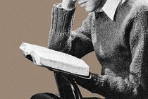 A man in a sweater reading a book, with only the lower half of his face showing