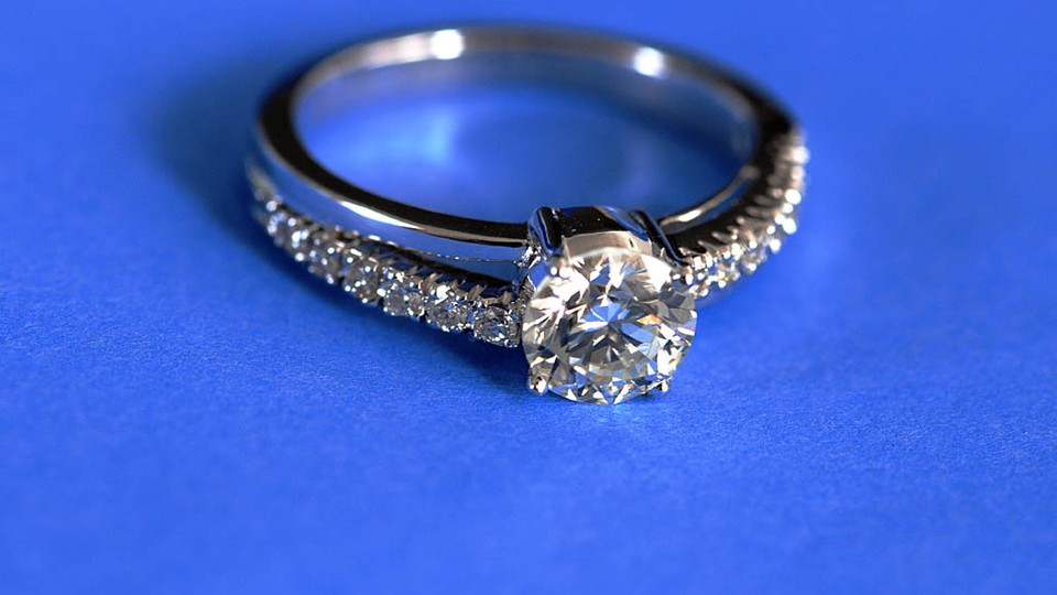 A diamond engagement ring on a blue background