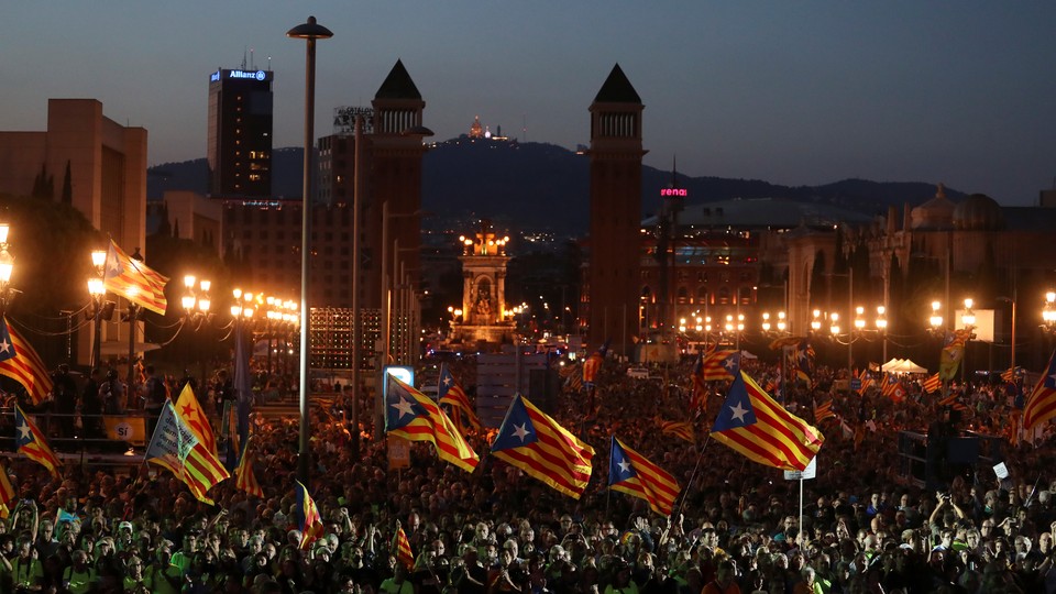 People wave Catalan separatist flags at a rally