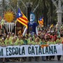 Demonstrators carry a banner, which reads: "Decided, Catalan school."