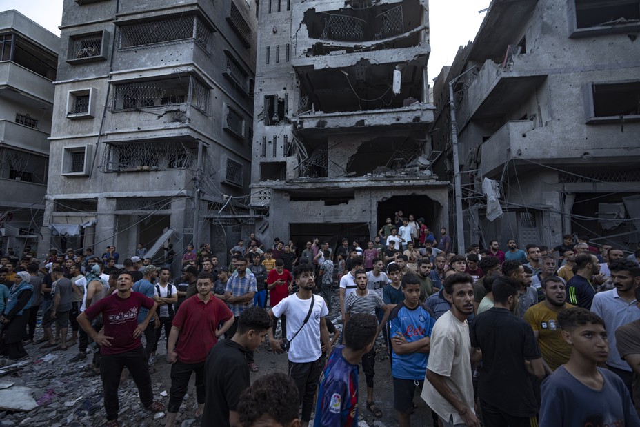 Picture of Palestinians watching others looking for injured in the rubble of a destroyed residential building following an Israeli airstrike, Tuesday, Oct. 10, 2023.