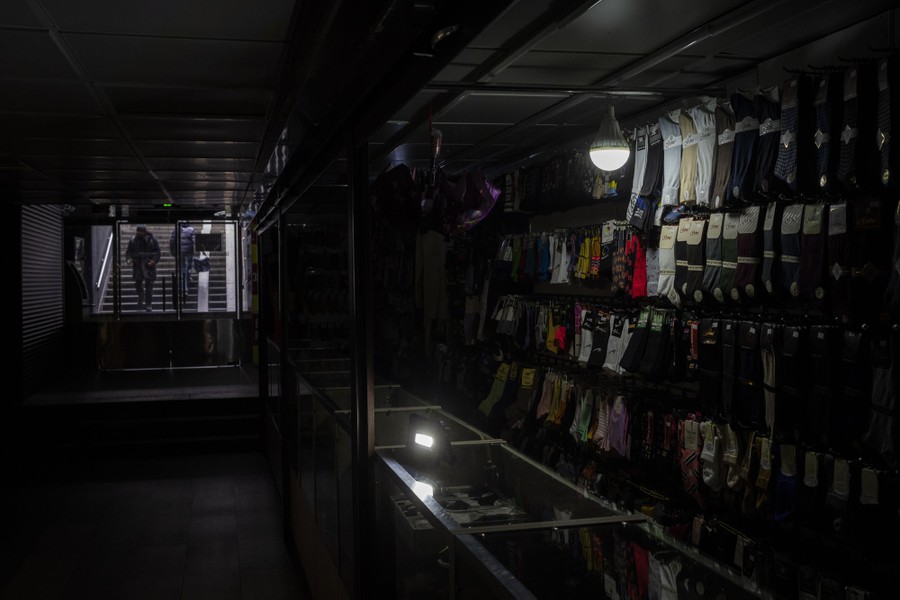 Camping lights illuminate a shop selling socks during a power outage.