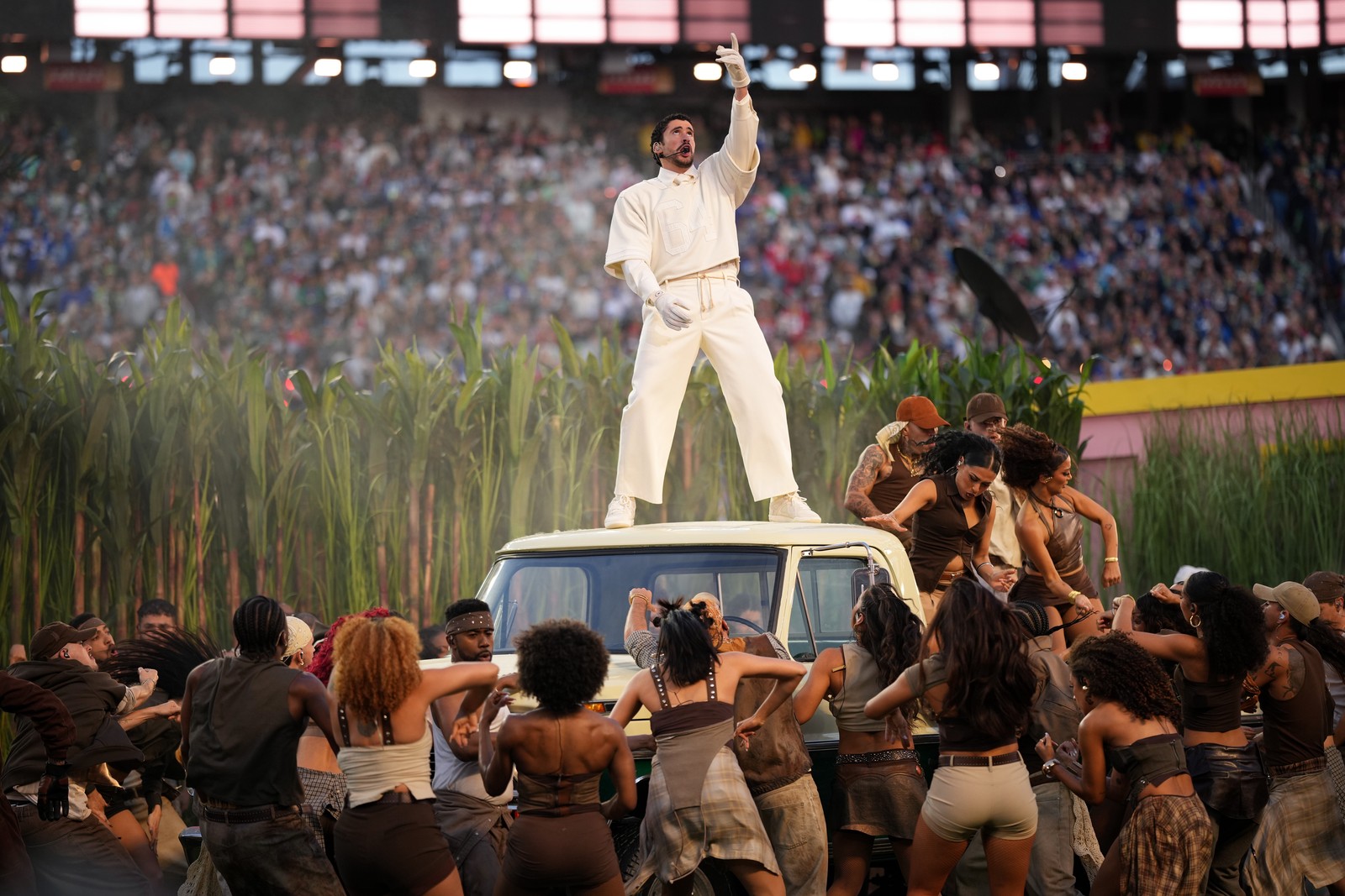 Bad Bunny performs during halftime of Super Bowl 60, standing atop a pickup truck, surrounded by dancers.