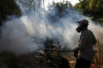 A health worker fumigates a neighborhood on the outskirts of Panama City