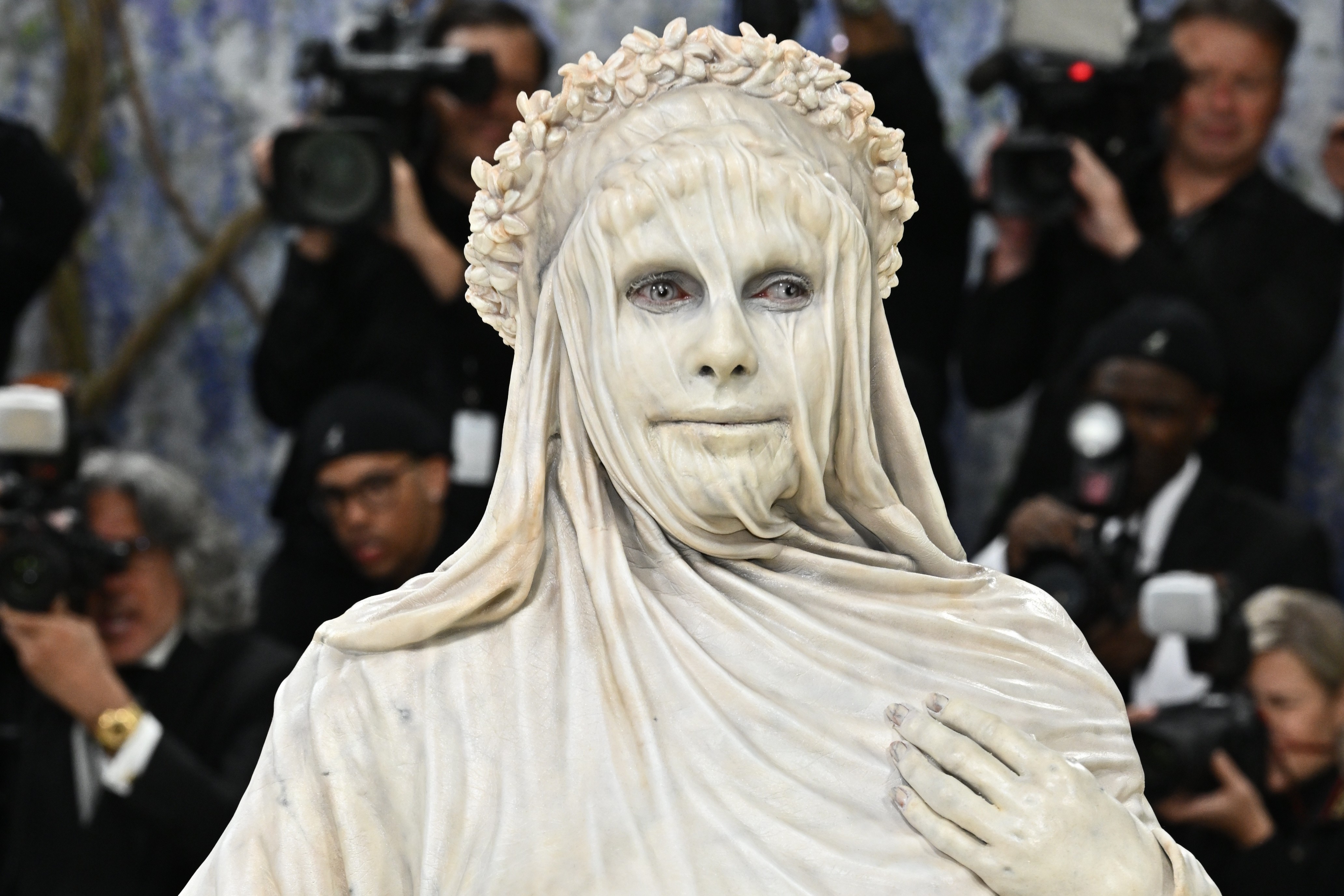 Heidi Klum arrives at the Met Gala, wearing a costume that makes her look like a carved marble statue with a veil and gown.