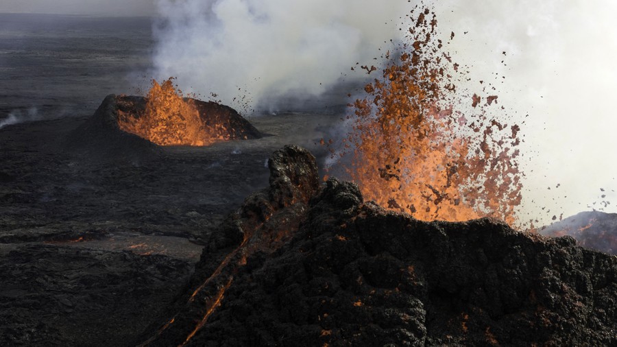 Lava erupts from two volcanic cones.
