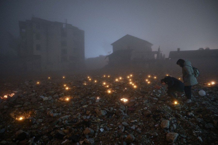 People leave candles at the site of a demolished building on the anniversary of last year's earthquake in Turkey.
