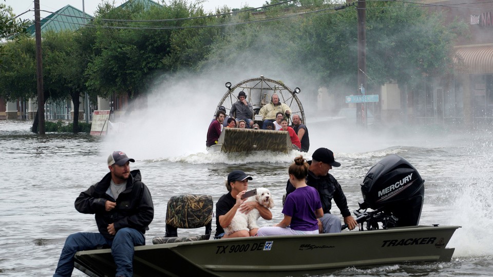 People are rescued from flood waters from tropical storm Harvey in Dickinson, Texas, on August 27, 2017.