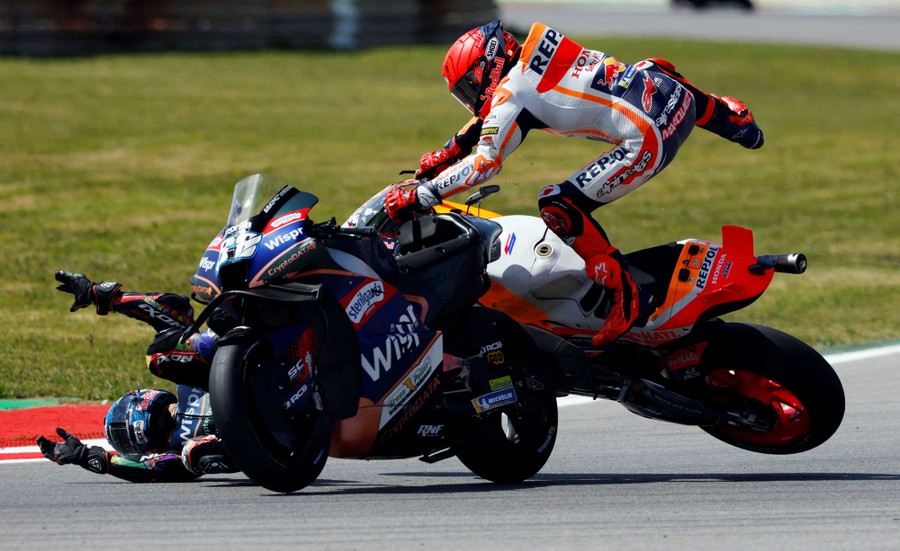 Two MotoGP motorcycle riders crash during a race.
