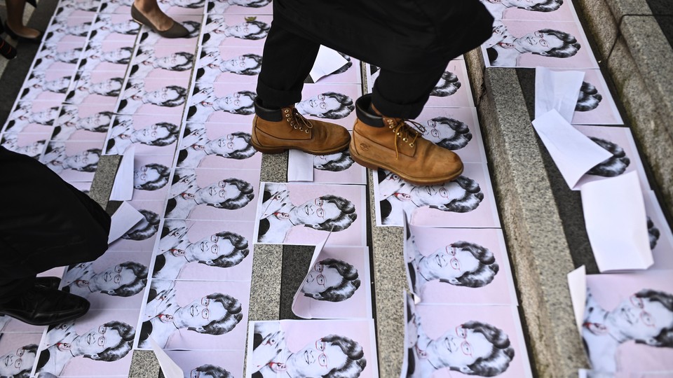 People walk over pictures of Hong Kong's chief executive, Carrie Lam.