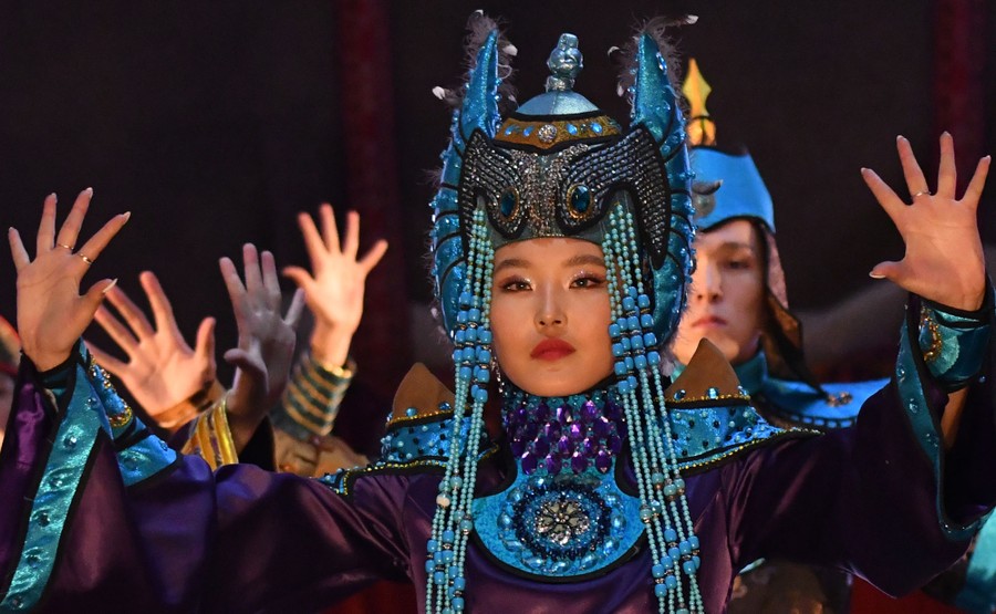 Models display elaborate headgear and colorful fashions.