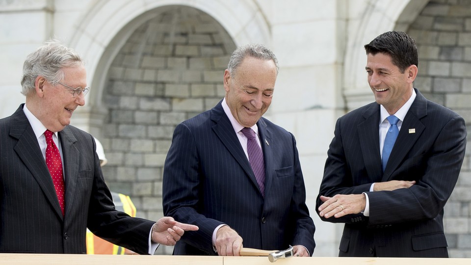 House Speaker Paul Ryan, right, and Senate Majority Leader Mitch McConnell, left, laugh at Senator Charles Schumer during a ceremony to drive in the first nails to signify the start of construction on the 2017 presidential inaugural platform on Capitol Hill in Washington.