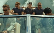 Chris Hemsworth drives a boat while wearing shades