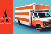 A photo-illustration of an orange-and-white moving truck without wheels, sitting up on cylinder blocks