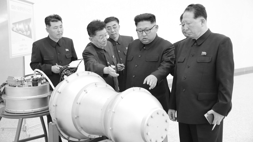 Kim Jong Un looking at machinery with advisers