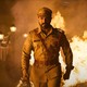 Ram Charan walking away from a burning building in "RRR"