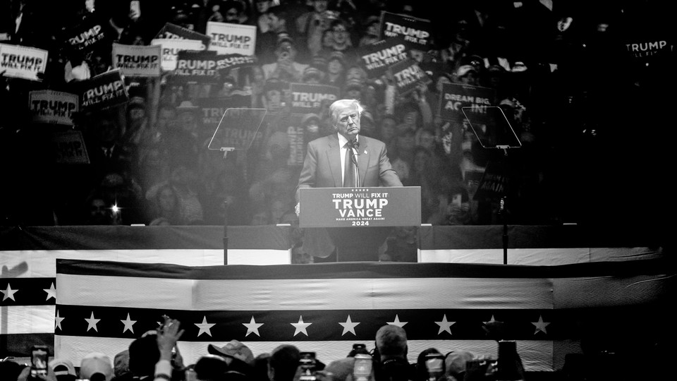 A black-and-white photo of Donald Trump standing at a podium speaking to a crowd at Madison Square Garden