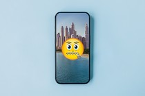 A zipped-lips emoji is superimposed over a picture of the Dubai skyline.