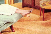 A woman's legs and feet hang over the end of a couch in a therapy office.