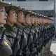 Female soldiers stand side-by-side in close formation, seen from the side.