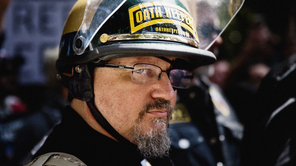 Color photograph of Stewart Rhodes wearing an Oath Keepers helmet